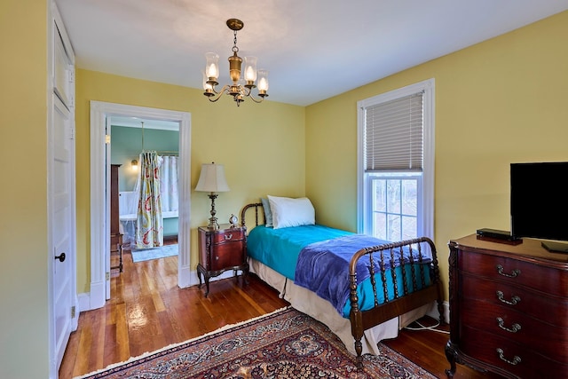 bedroom with an inviting chandelier, baseboards, and hardwood / wood-style flooring