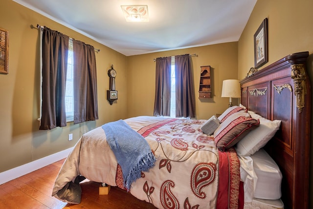 bedroom featuring baseboards and wood-type flooring