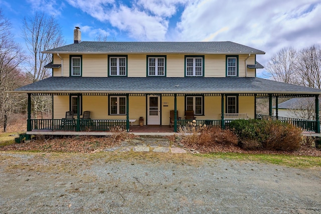 farmhouse featuring a porch and a chimney