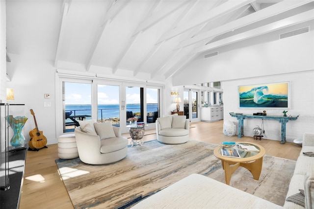 living room featuring visible vents, wood finished floors, beam ceiling, high vaulted ceiling, and a water view