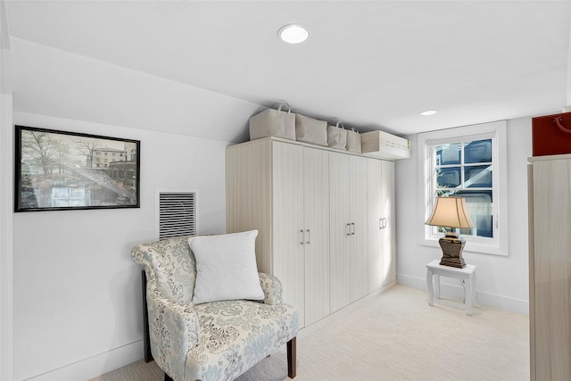living area with baseboards, visible vents, light carpet, and vaulted ceiling
