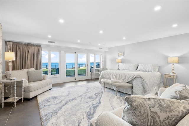 bedroom featuring visible vents, access to outside, recessed lighting, a water view, and concrete floors