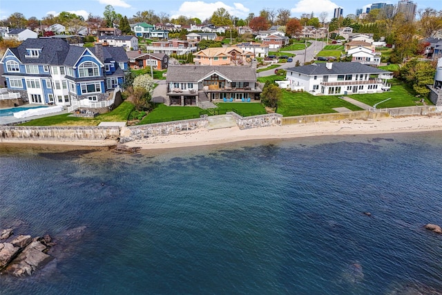 drone / aerial view with a beach view, a water view, and a residential view