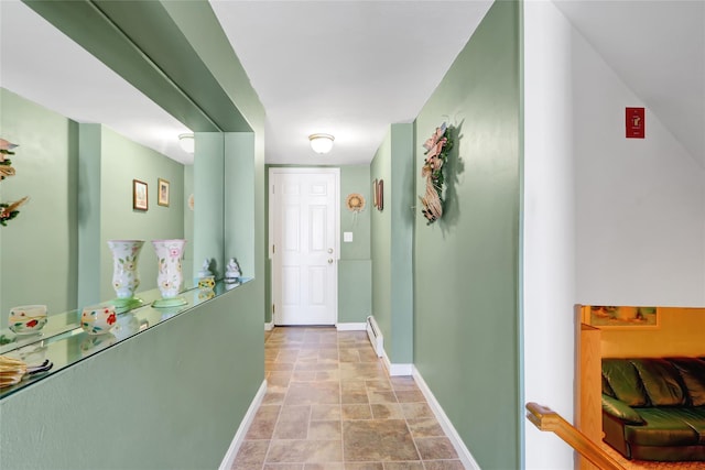 corridor with baseboard heating and baseboards