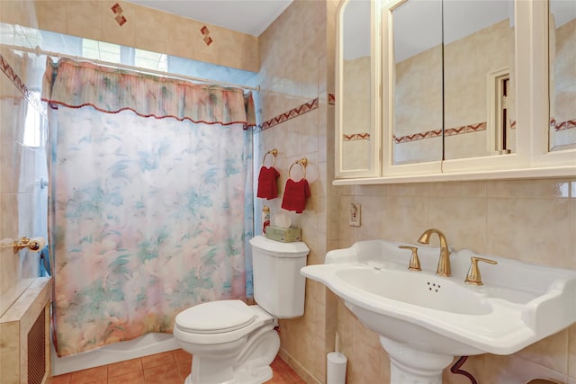 bathroom with shower / tub combo, tile patterned floors, toilet, tile walls, and a sink