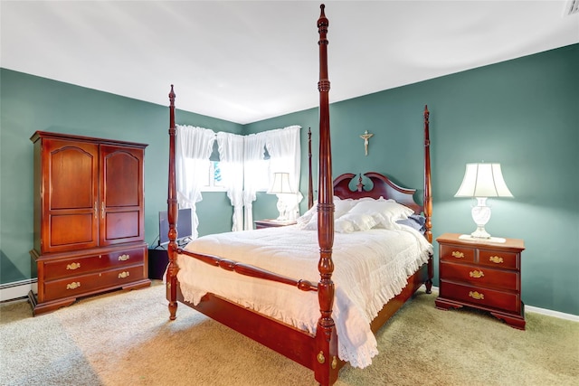 carpeted bedroom with a baseboard heating unit and baseboards