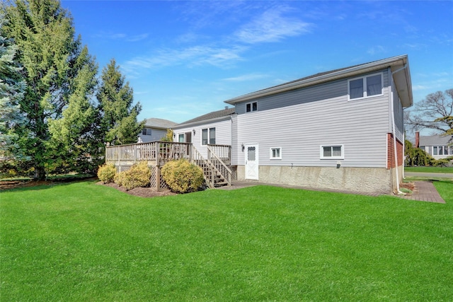rear view of house featuring a deck and a lawn