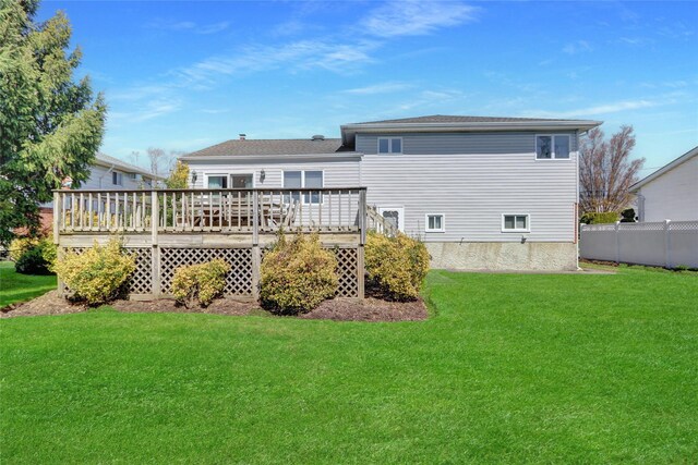 back of house with a yard, fence, and a deck