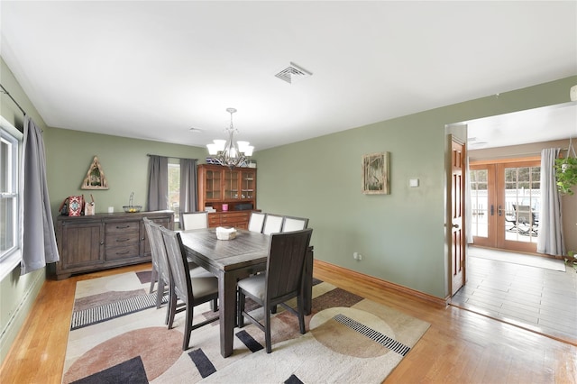 91 Meyerhoff Rd, Hurleyville, NY 12747 - dining space with french doors, visible vents, an inviting chandelier, and light wood-style floors