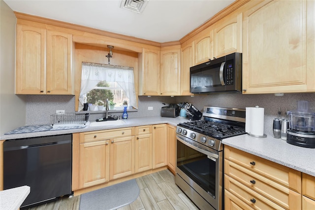 91 Meyerhoff Rd, Hurleyville, NY 12747 - kitchen with light brown cabinetry, gas range, dishwasher, and a sink