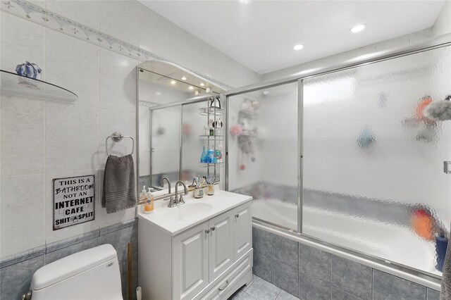 91 Meyerhoff Rd, Hurleyville, NY 12747 - bathroom featuring vanity, tiled shower / bath, tile patterned floors, toilet, and tile walls
