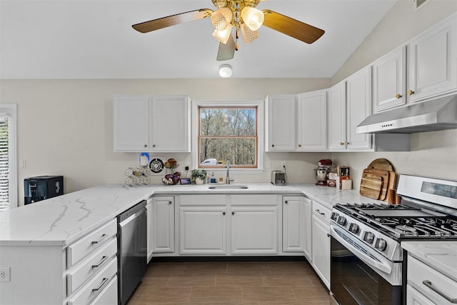 kitchen with under cabinet range hood, a sink, a peninsula, appliances with stainless steel finishes, and white cabinetry