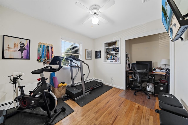 workout area featuring baseboards, a ceiling fan, built in features, and wood finished floors