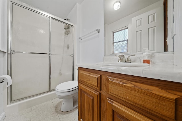 full bathroom featuring vanity, toilet, tile patterned flooring, and a stall shower