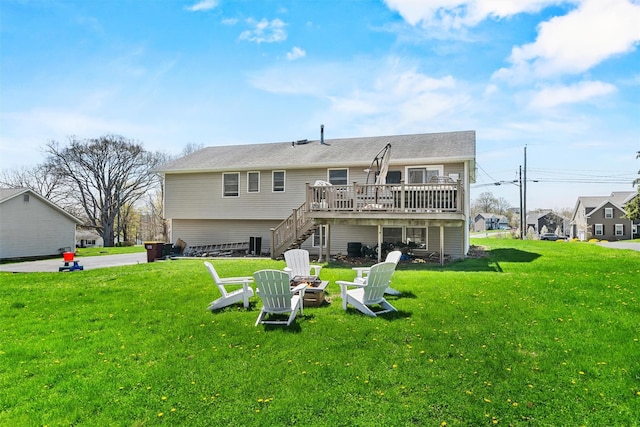 back of house featuring stairway, a deck, a yard, and an outdoor fire pit