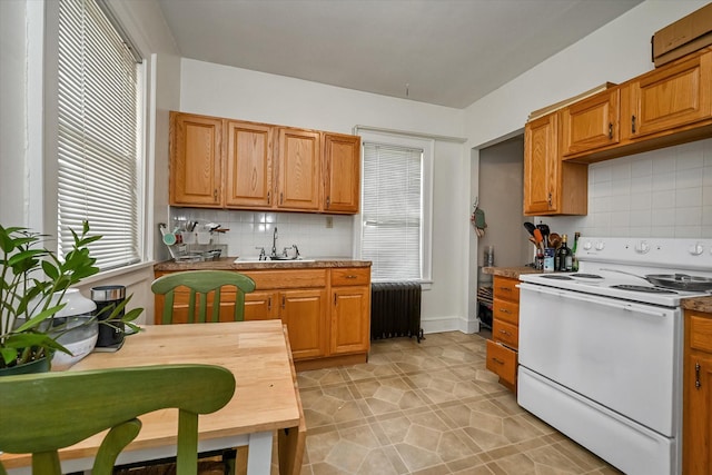 kitchen featuring light tile patterned floors, radiator heating unit, white range with electric stovetop, a sink, and decorative backsplash