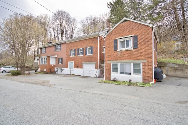9 Old Albany Post Rd N, Cold Spring, NY 10516 - back of house with a chimney, brick siding, and a garage