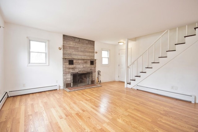 9 Old Albany Post Rd N, Cold Spring, NY 10516 - unfurnished living room with wood finished floors, a fireplace, stairs, and a baseboard radiator