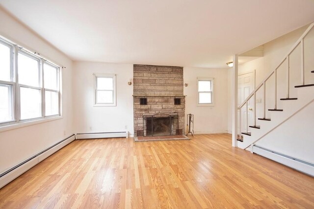 9 Old Albany Post Rd N, Cold Spring, NY 10516 - unfurnished living room featuring a baseboard heating unit, light wood-type flooring, and stairway