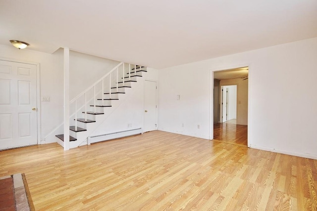 9 Old Albany Post Rd N, Cold Spring, NY 10516 - unfurnished living room featuring light wood-style floors, baseboards, stairs, and baseboard heating
