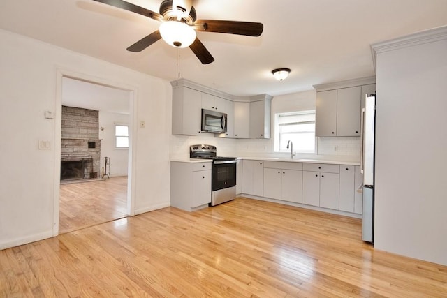 9 Old Albany Post Rd N, Cold Spring, NY 10516 - kitchen featuring gray cabinetry, light wood-style floors, appliances with stainless steel finishes, and tasteful backsplash