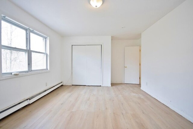 9 Old Albany Post Rd N, Cold Spring, NY 10516 - unfurnished bedroom with a baseboard radiator, light wood-type flooring, a closet, and baseboards