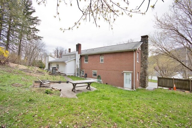 9 Old Albany Post Rd N, Cold Spring, NY 10516 - back of house with a chimney, brick siding, and a yard
