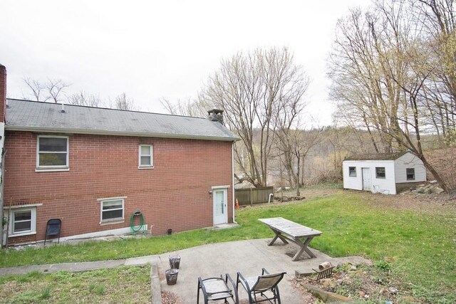 9 Old Albany Post Rd N, Cold Spring, NY 10516 - back of house with a chimney, a yard, a patio area, an outbuilding, and brick siding