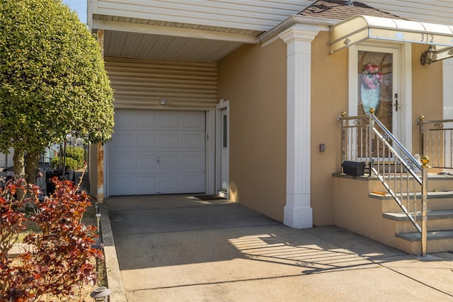 exterior space with concrete driveway, stucco siding, and a garage