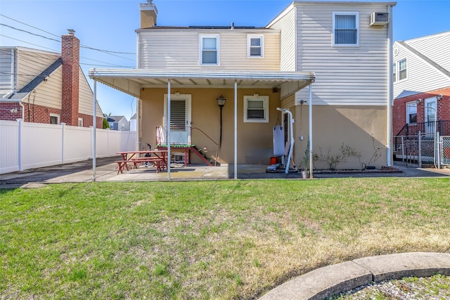 rear view of property with a patio, stucco siding, fence, and a lawn