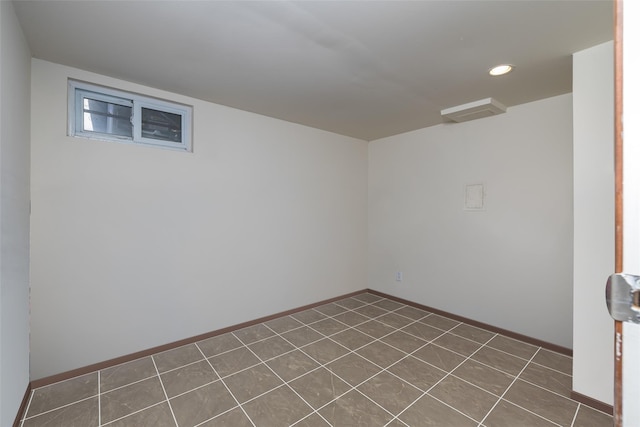 spare room featuring recessed lighting, baseboards, and dark tile patterned flooring