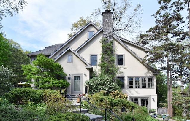 view of front facade featuring stucco siding and a chimney