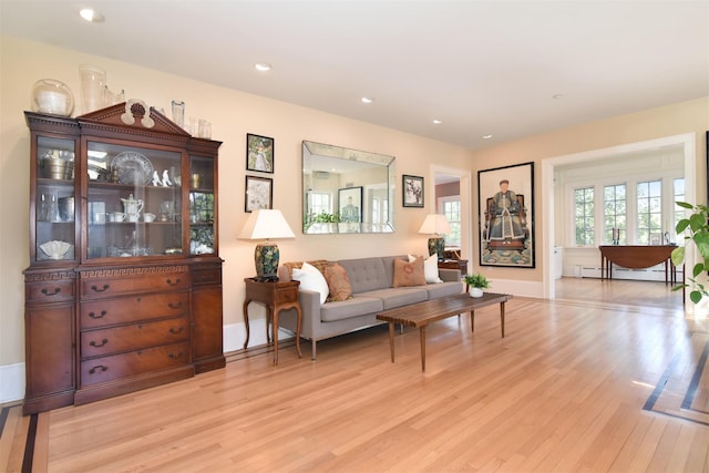 living area featuring recessed lighting, a baseboard radiator, light wood finished floors, and baseboards