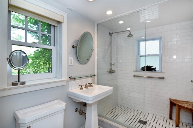 bathroom featuring recessed lighting, toilet, and tiled shower