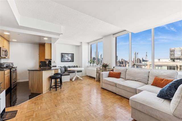 4-74 48th Ave Unit Ph4D, Long Island City, NY 11109 - living area with a view of skyline, baseboards, recessed lighting, and a textured ceiling
