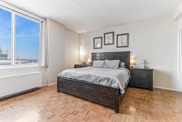 4-74 48th Ave Unit Ph4D, Long Island City, NY 11109 - bedroom with radiator heating unit, a textured ceiling, and baseboards