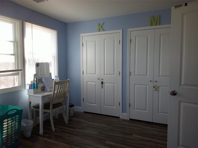 office with dark wood-style flooring, visible vents, and baseboards