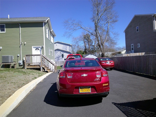 view of side of home featuring central air condition unit and fence