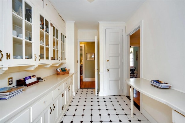 interior space featuring white cabinets, glass insert cabinets, and light countertops
