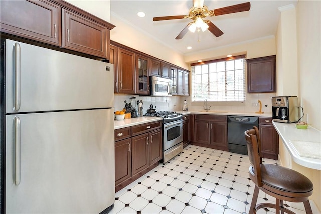 kitchen with light countertops, appliances with stainless steel finishes, a sink, and light floors