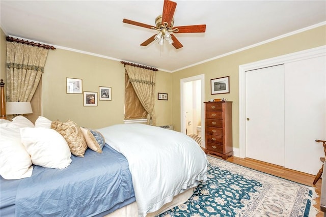bedroom with a ceiling fan, ornamental molding, a closet, and light wood-type flooring