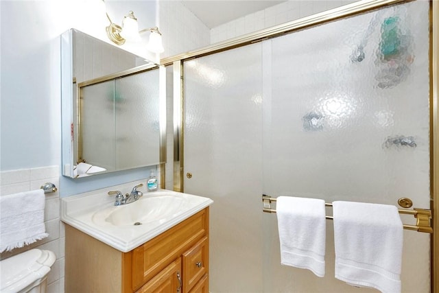 full bath with vanity, a shower with door, and toilet