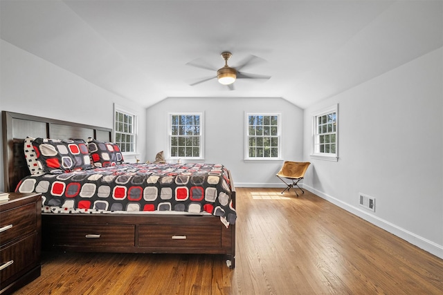 bedroom with baseboards, vaulted ceiling, visible vents, and dark wood-type flooring