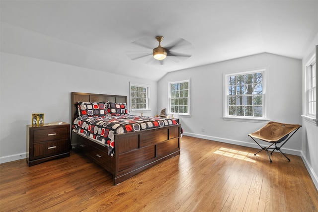 bedroom with lofted ceiling, hardwood / wood-style floors, baseboards, and ceiling fan