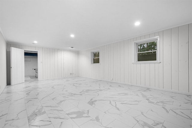 empty room featuring recessed lighting, wooden walls, and marble finish floor
