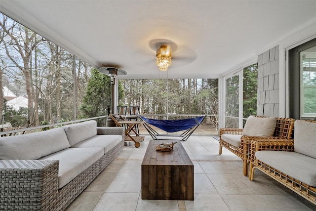 sunroom with ceiling fan and an outdoor living space