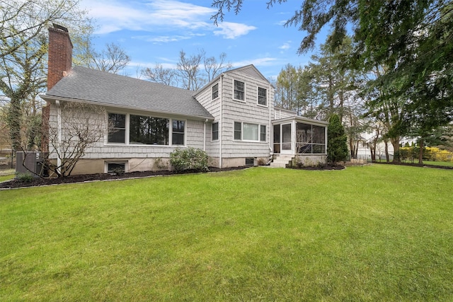 view of front of house with a chimney, a sunroom, a shingled roof, and a front yard