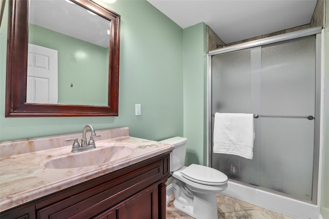 bathroom featuring vanity, a shower stall, and toilet