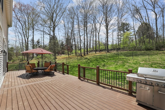 wooden terrace featuring a yard and a grill