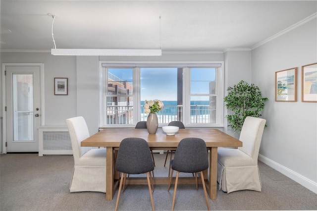 carpeted dining room with healthy amount of natural light, ornamental molding, and baseboards